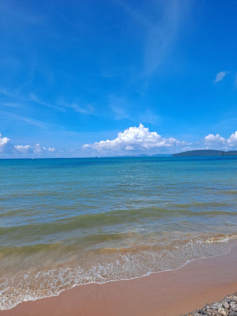 beach in krabi, thailand. blue sky with white clouds, waves and sand